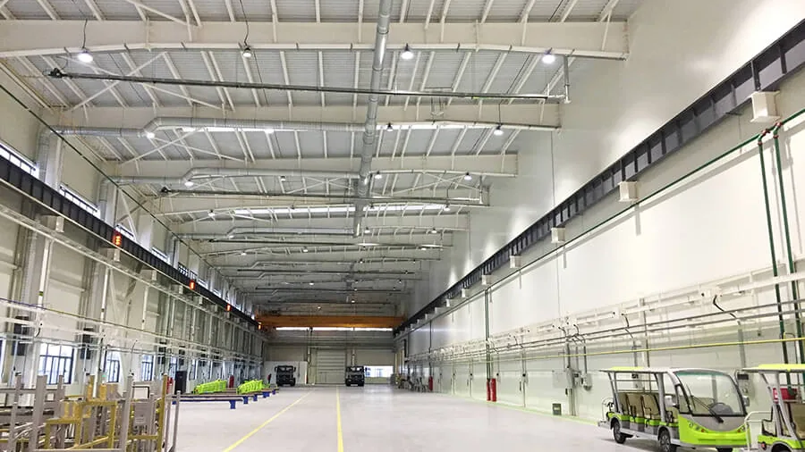 Factory interior at night with an even lit ceiling and a clear working floor